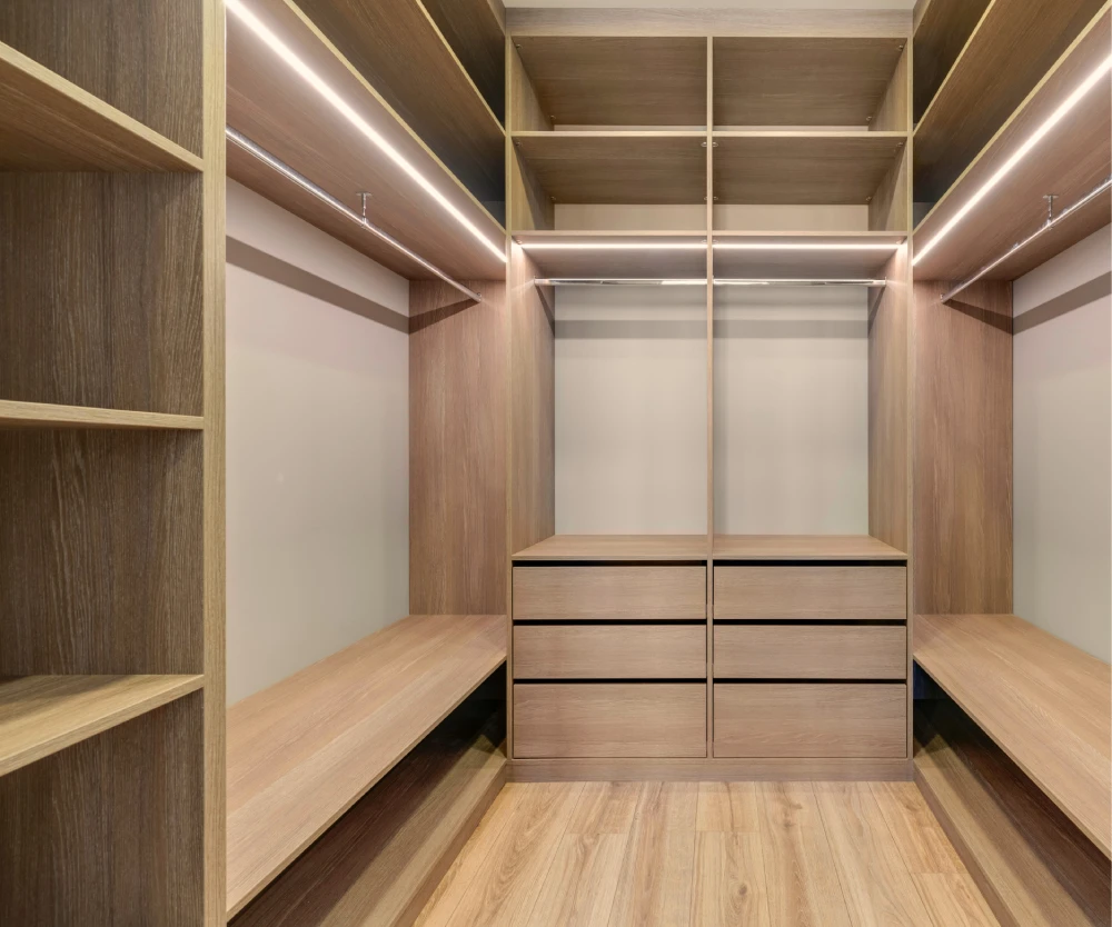 Dressing 3D en chêne sur-mesure lumineux grâce aux rubans led, avec de nombreux rangements, des penderies et tiroirs.