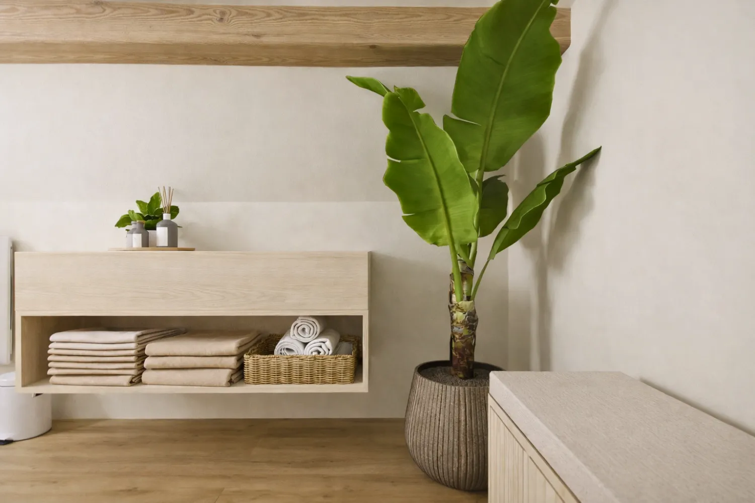 Salle de bain avec un banc pour le confort, un plante xxl et un meuble de rangements suspendu en chêne massif.